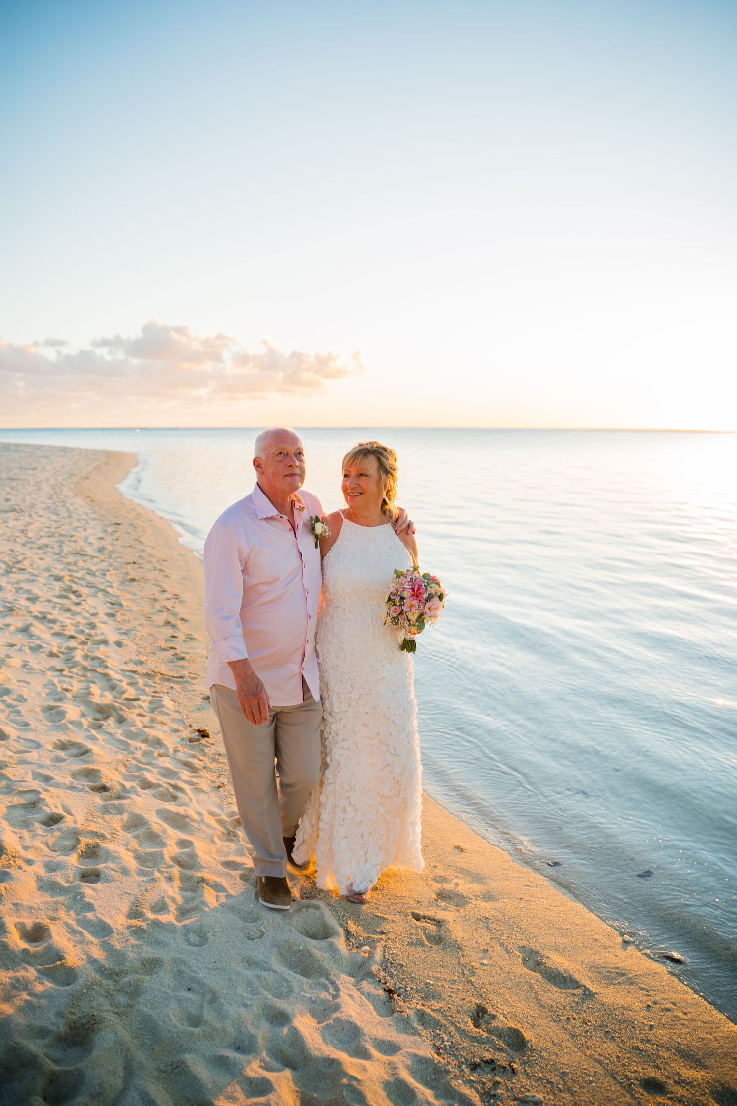 Couple standing side by side at golden hour on the beach during their Mauritius destination wedding