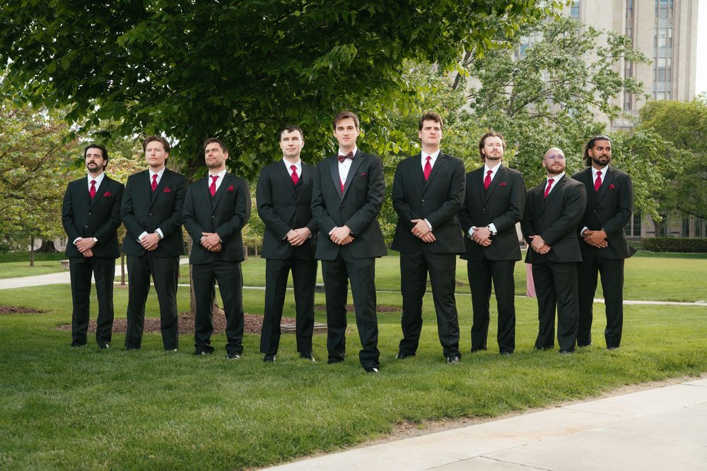 Groom posing with his groomsmen during an outdoor wedding portrait.
