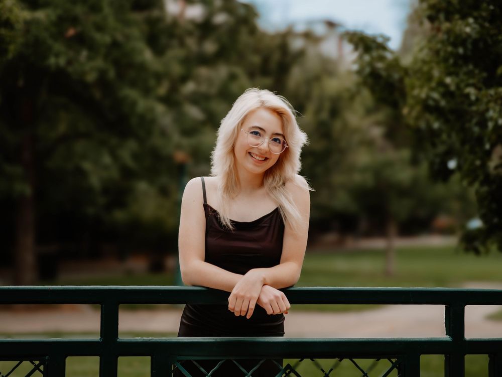 Girl poses leaning for senior photos, cinematic photos, and portraits in Arvada, Colorado outside and in nature photo