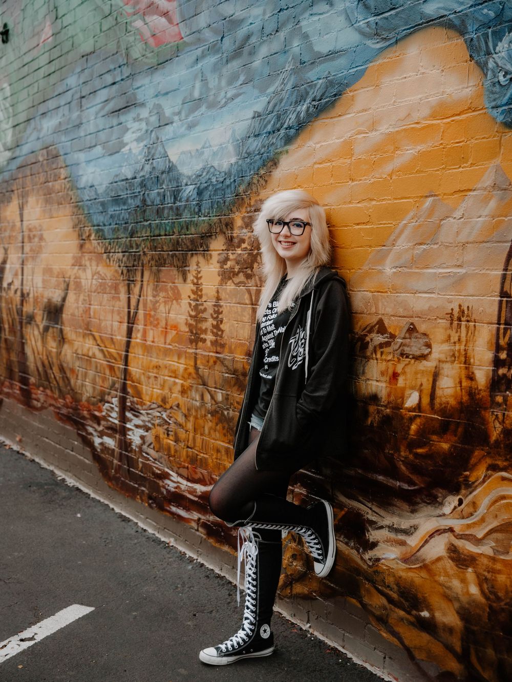 Girl poses leaning on wall for senior photos, cinematic photos, and portraits in Arvada, Colorado outside and in nature photo