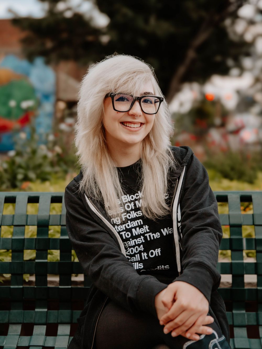 Girl sits down and poses for senior photos, cinematic photos, and portraits in Arvada, Colorado outside and in nature photo