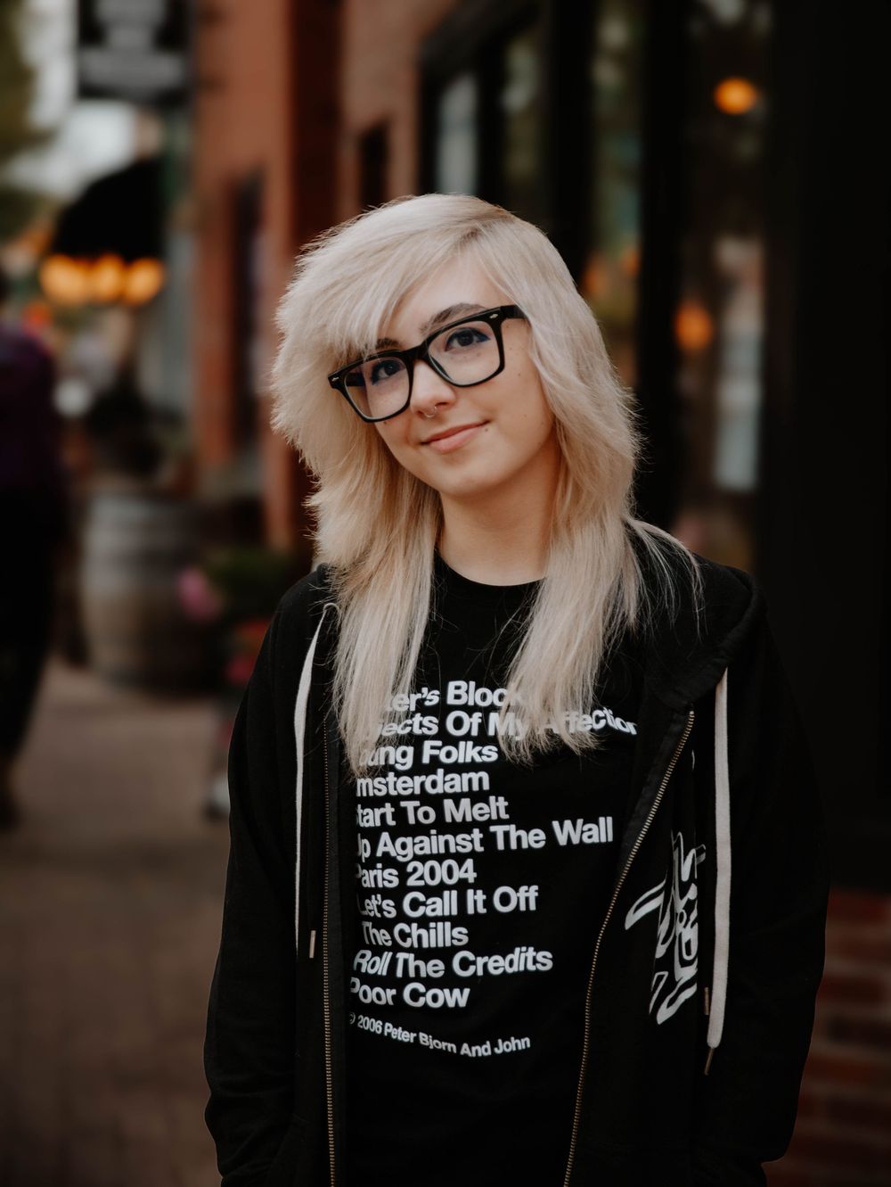Girl stands and poses for senior photos in an urban town, cinematic photos, and portraits in Arvada, Colorado outside and in nature photo