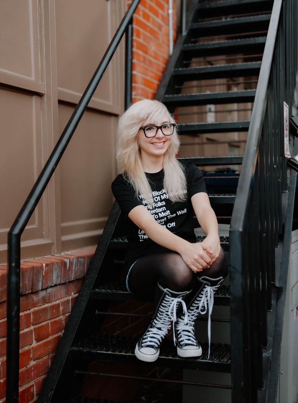 Girl sits on urban stairs and poses for senior photos, cinematic photos, and portraits in Arvada, Colorado outside and in nature photo