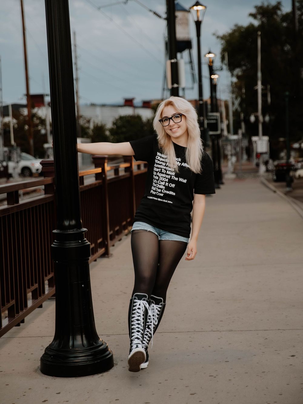 Girl swings on pole and poses for senior photos, cinematic photos, and portraits in Arvada, Colorado outside and in nature photo