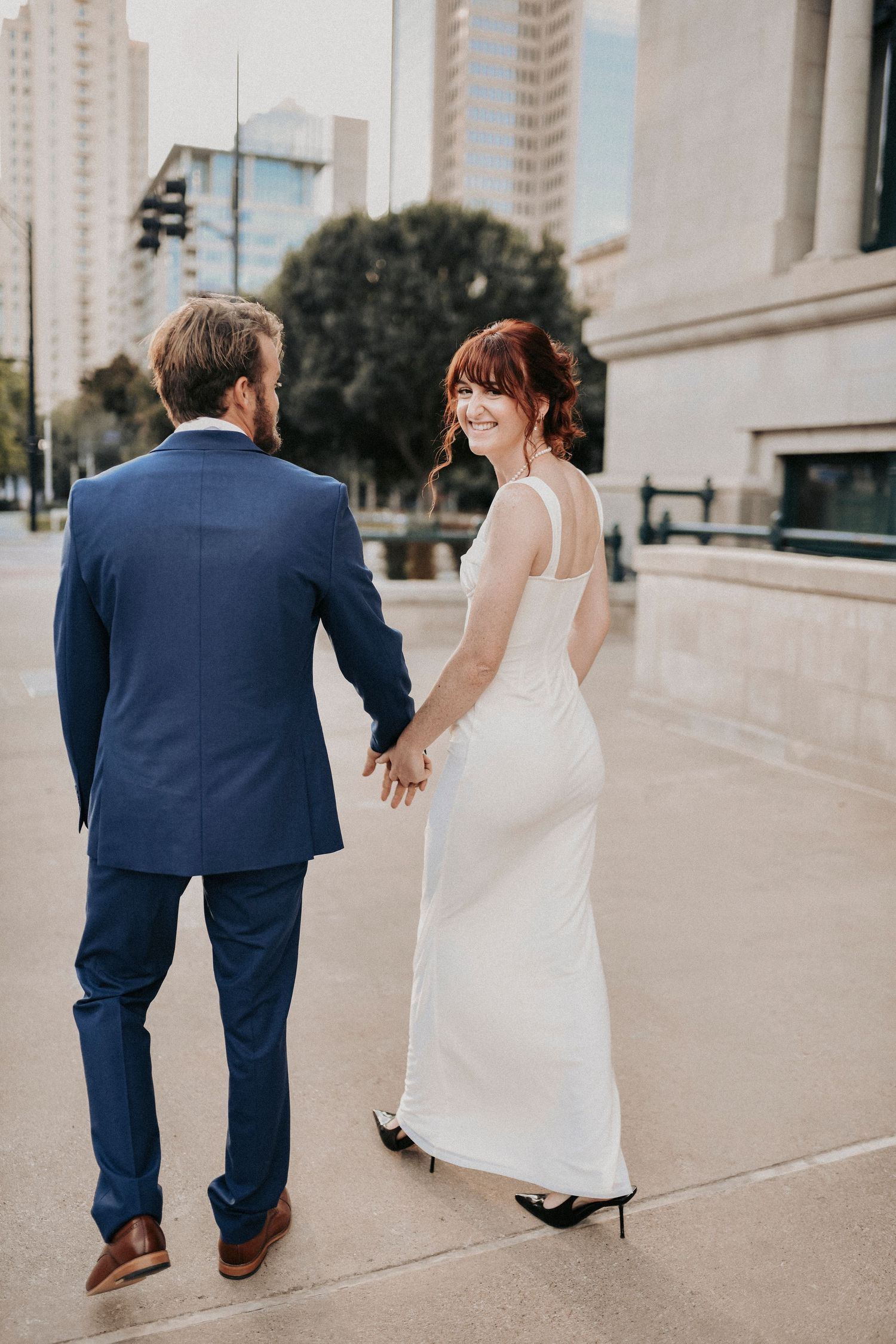 Couple holding hands while walking through Downtown Dallas streets