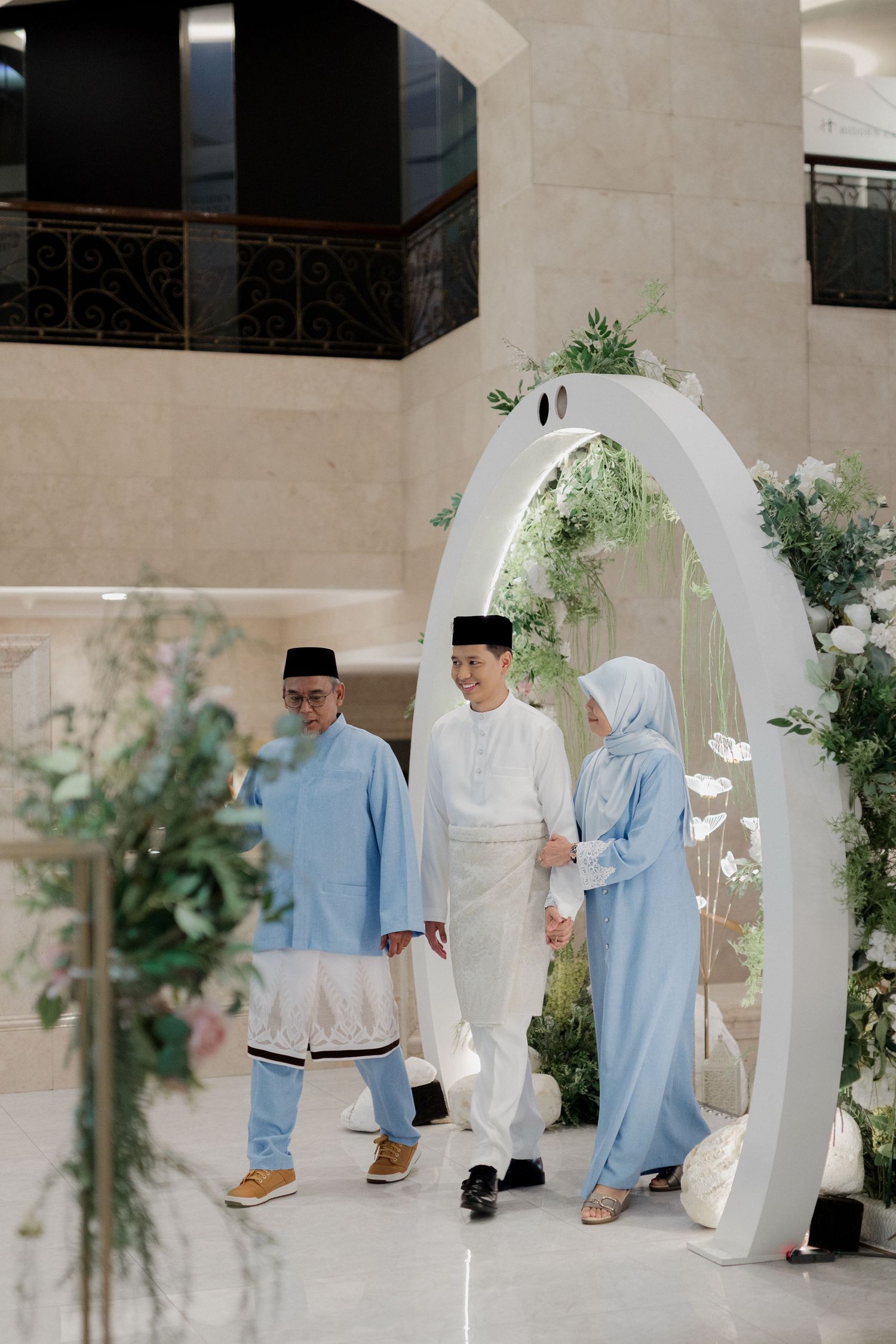 Couple walking together in a lush garden with manicured hedges and brick pathways.