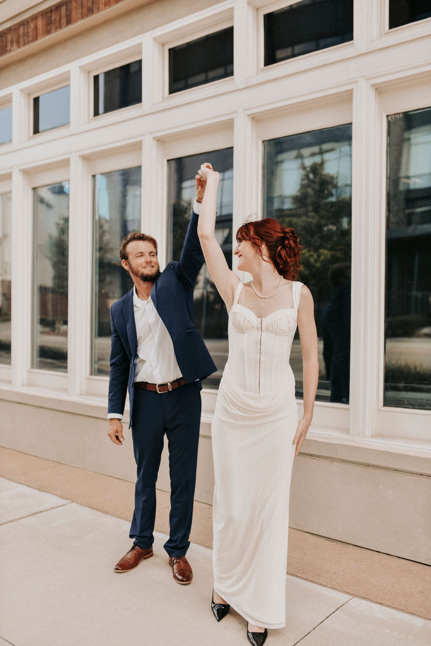 Couple twirling beneath elegant architecture at Dallas County Records Building