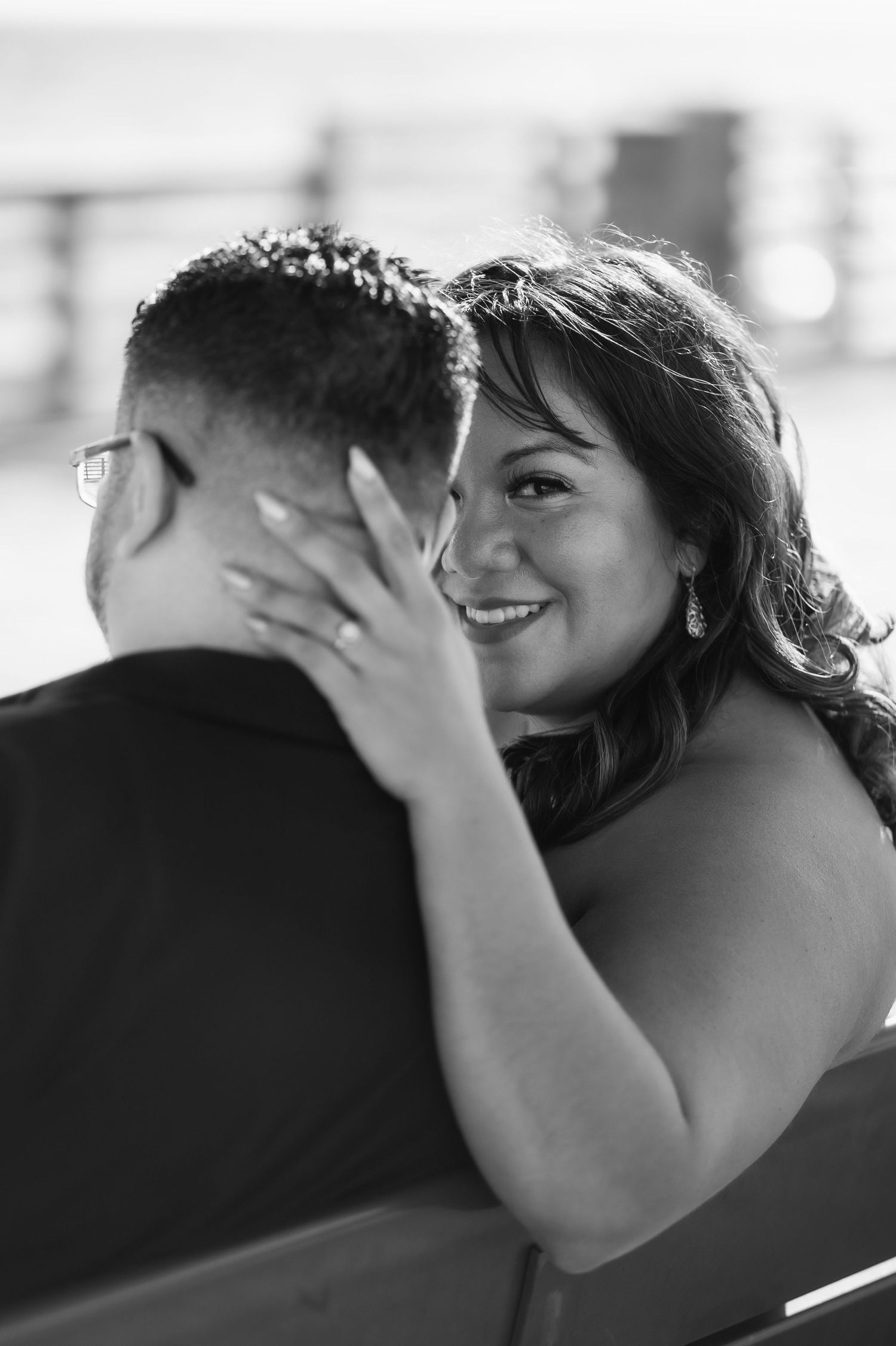 Couple embracing at Pompano Beach Pier during engagement couples session.