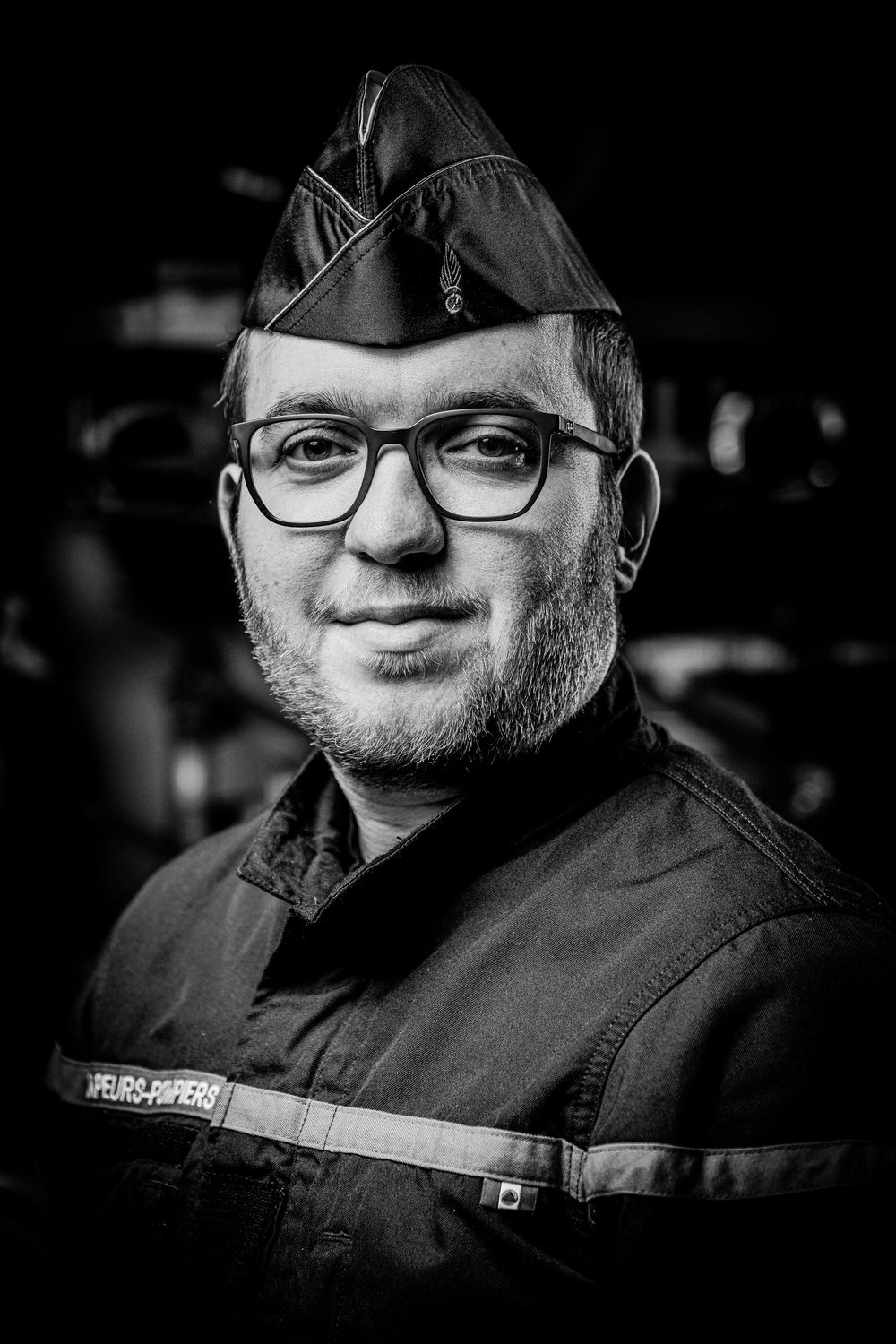 A series of black and white portrait photographs showing a person wearing glasses and dark clothing.