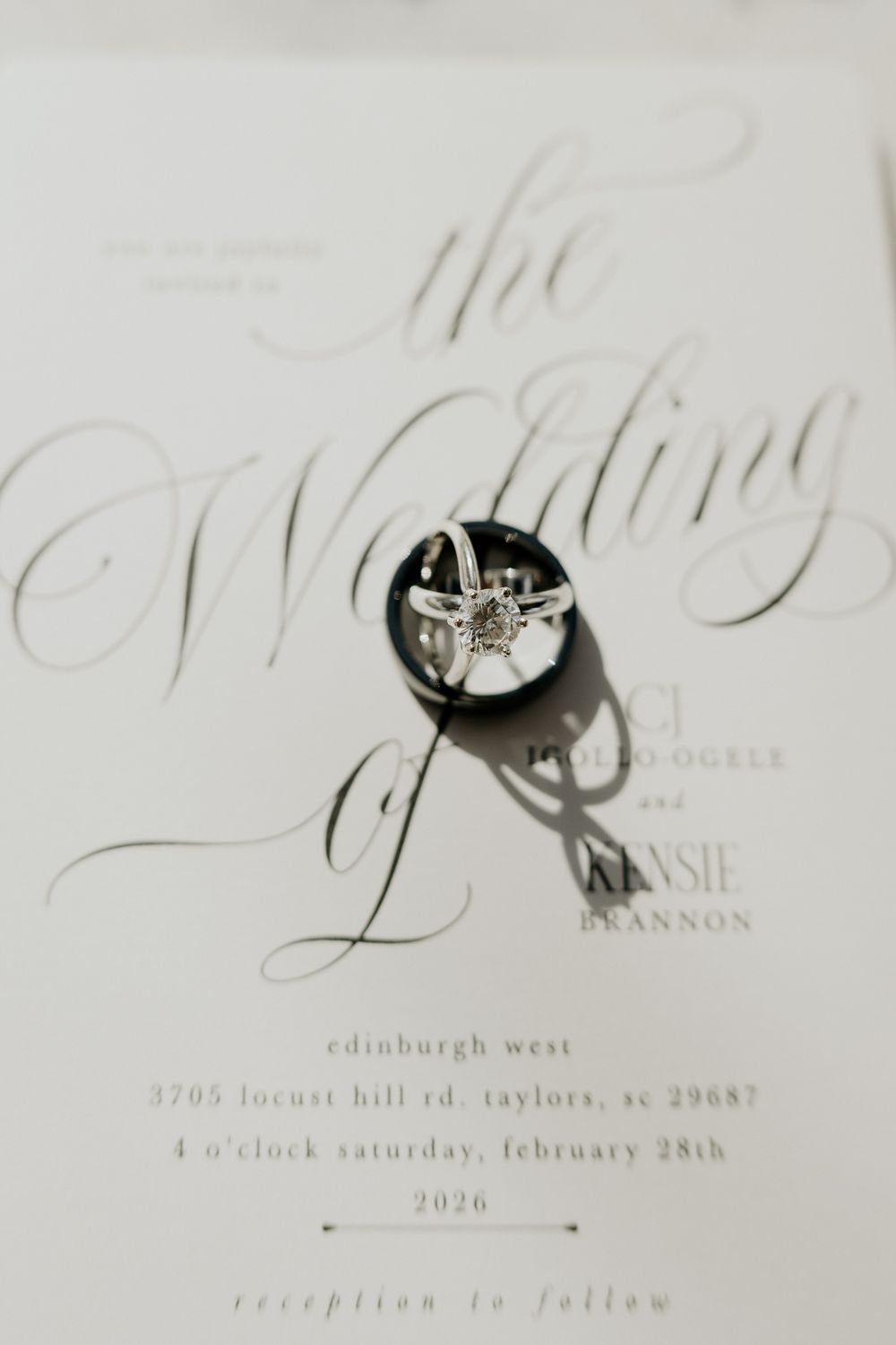 Elegant wedding invitation with calligraphy script and diamond engagement ring resting on top, February 28 2026 ceremony.