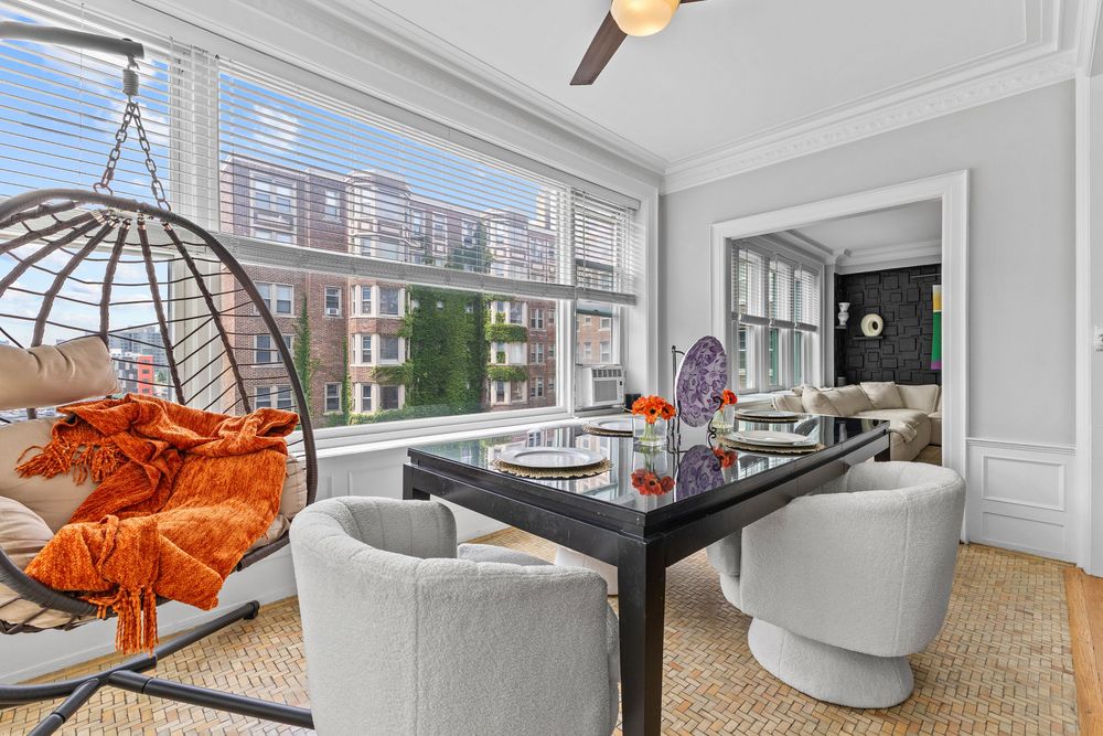 Dining area with panoramic windows and natural light inside a Detroit riverfront condominium.