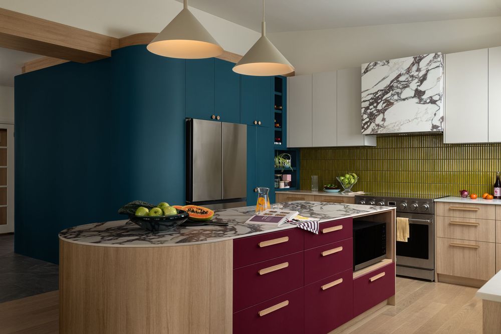 Contemporary kitchen featuring teal walls, marble island, burgundy cabinets, stainless appliances, and pendant lighting.