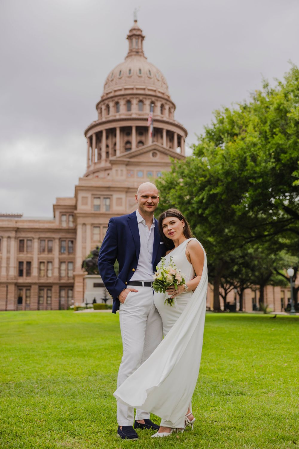 Bride and groom pose in front of the Texas State Capitol building on their wedding day in Austin, TX.