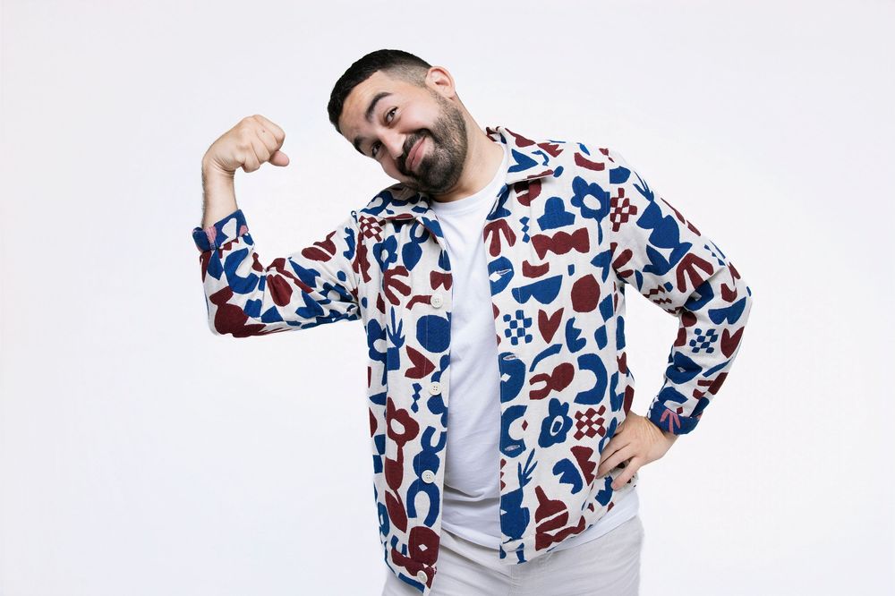 Person wearing a white and blue floral print button-up shirt laughs and poses in a sequence of four photos.