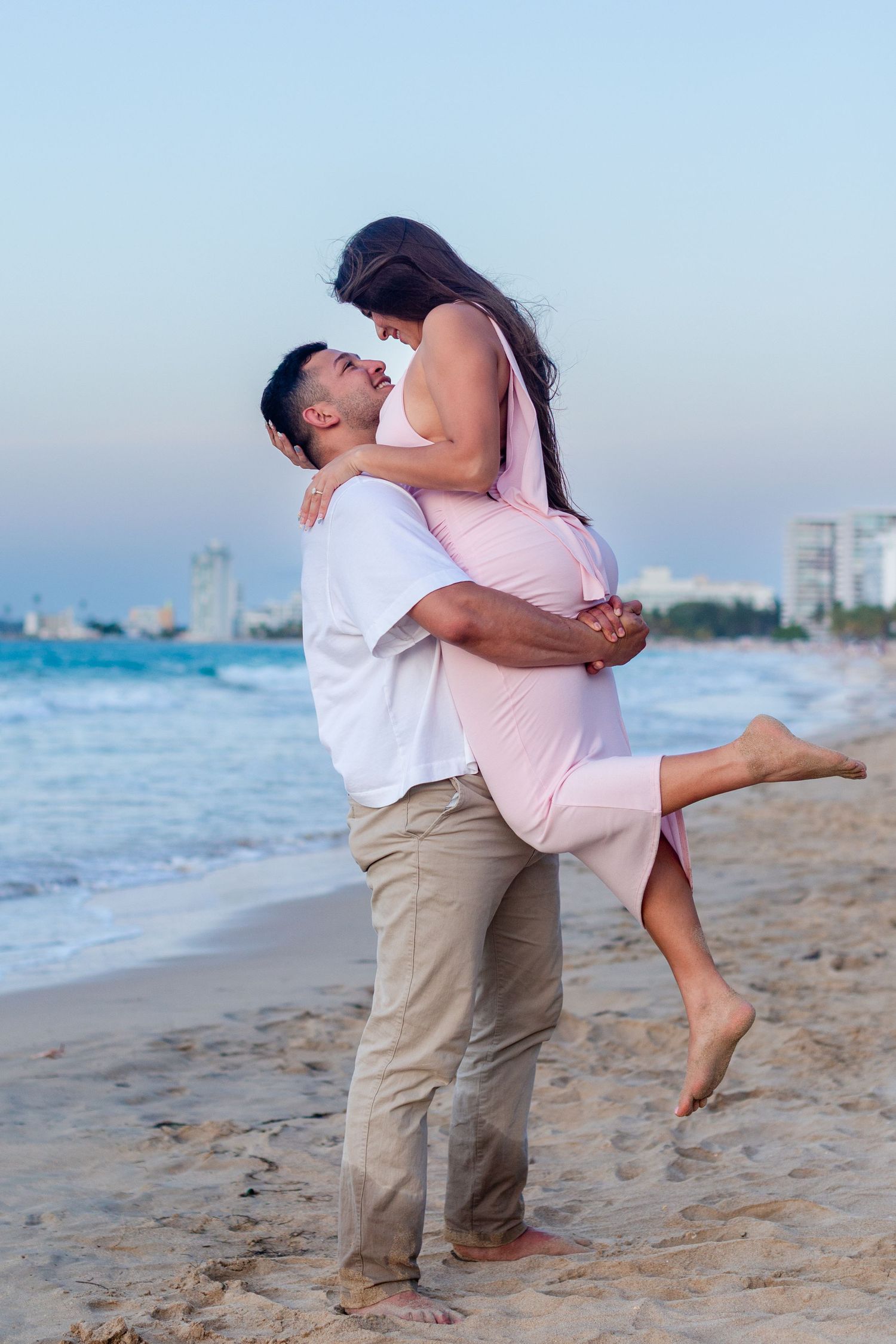 Couples portrait (man picking up woman) at the beach in Isla Verde, Carolina, Puerto Rico.