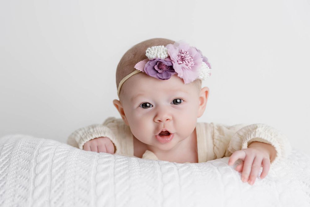 Adorable baby girl wearing a floral headband with purple flowers by Winchester two month old baby photographer.