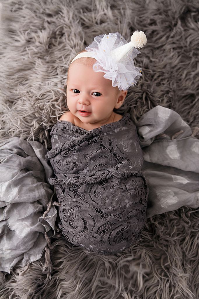 Adorable baby wrapped in gray lace swaddle with white bow headband by Winchester 2 month old baby photographer.