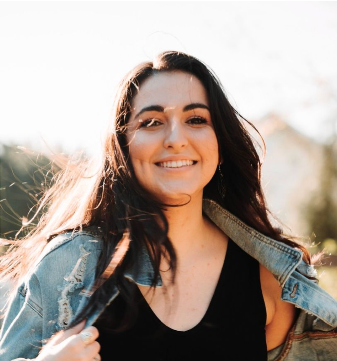 Alina, CEO of Ever Joy Photography smiling outdoors in sunlight wearing a denim jacket.
