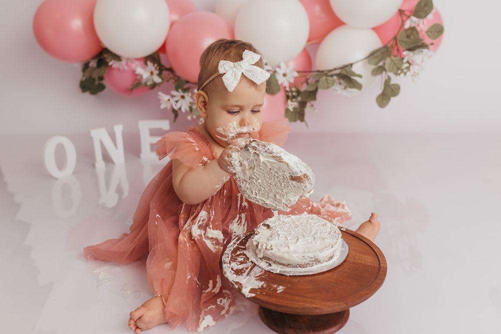 Baby taking a cake apart during her fun cake smash session to celebrate turning one.