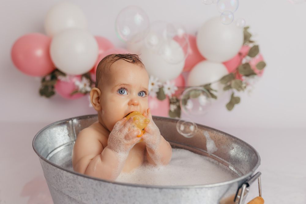 Baby girl taking a bubble bath after eating her first birthday cake in  her studio photos.