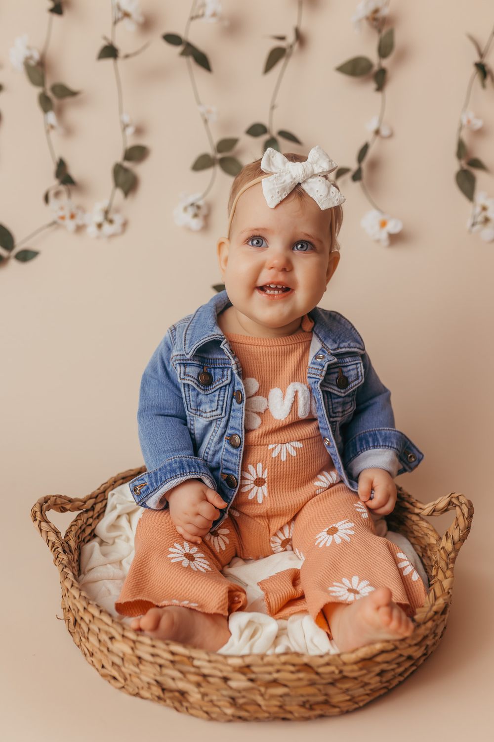 Baby girl smiling at the camera during her portrait portion of her cake smash / one year photography session