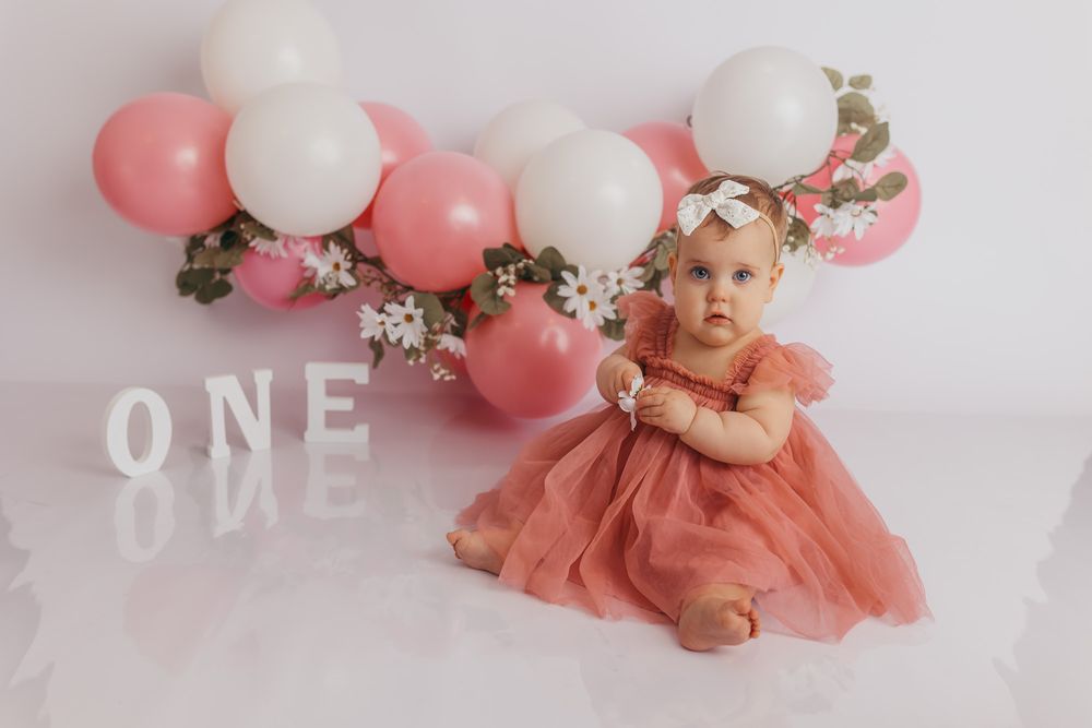 Baby girl looking at the camera during her portrait portion of her cake smash session in Schofield, WI