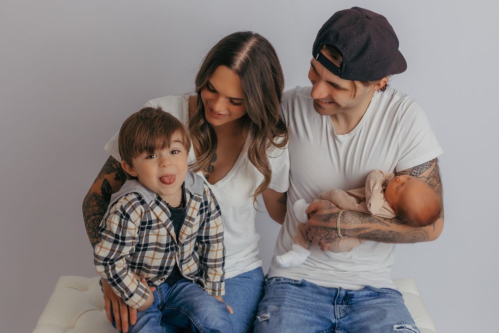 Toddler making a silly face at the camera during their newborn session.