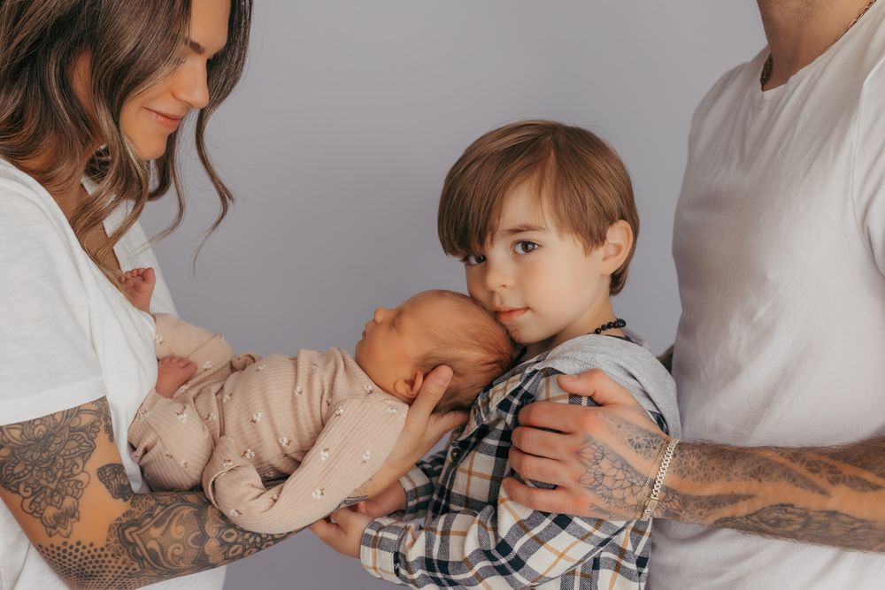 Big brother cuddling his new little sister during their newborn photos.