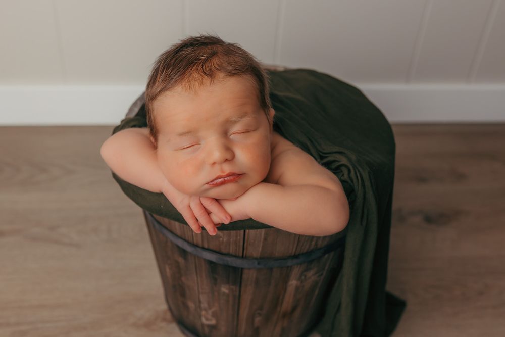 Baby sleeping in a bucket.