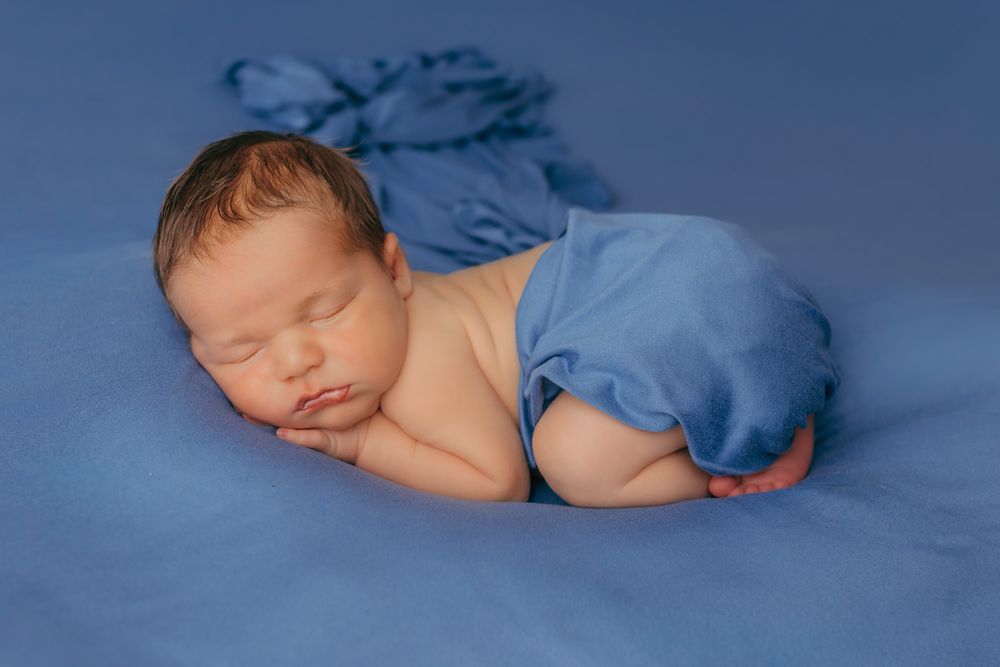 Baby curled up sleeping during their calm newborn photography session in Wisconsin.