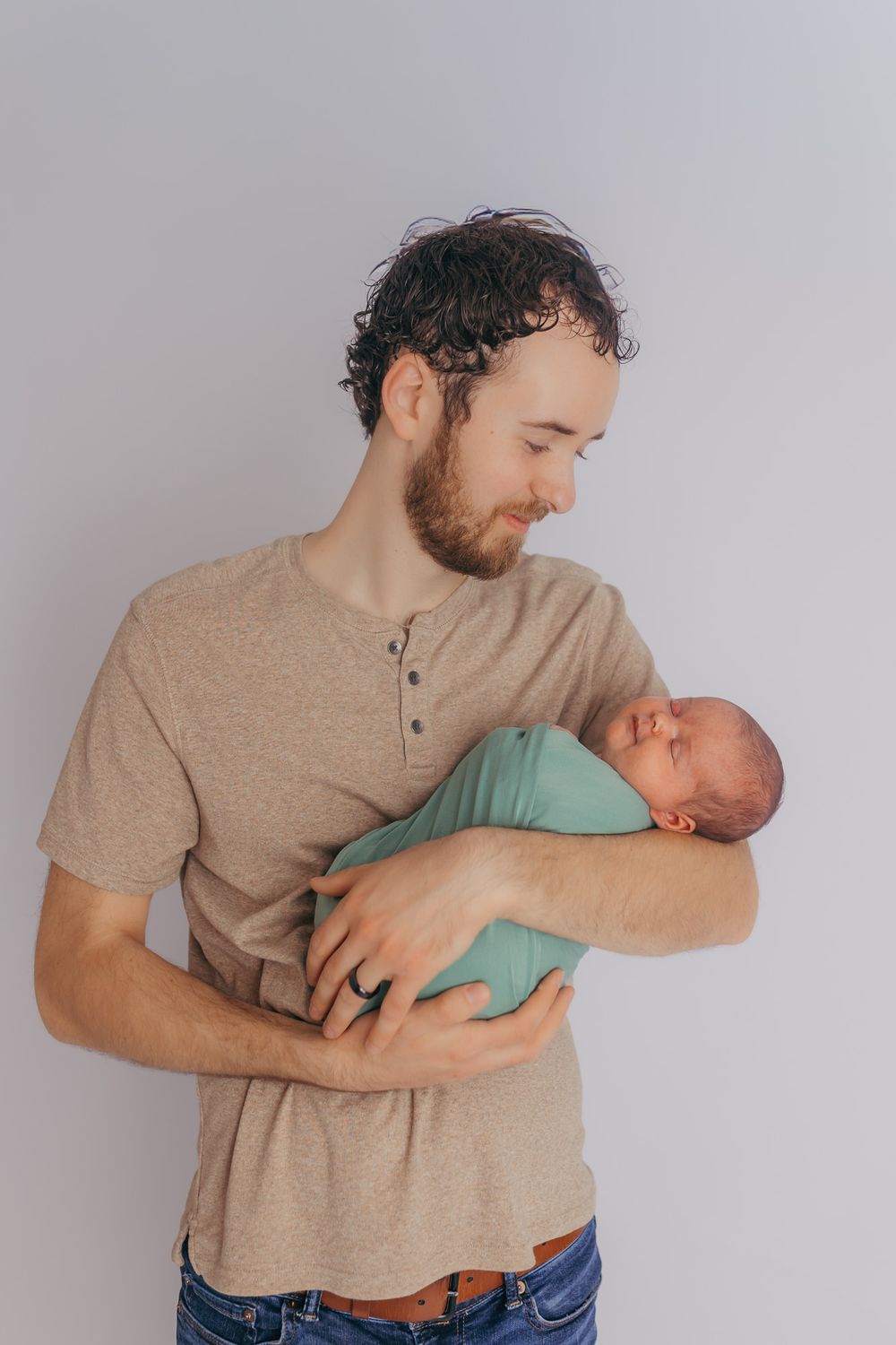 Dad admiring his newborn baby girl during their studio newborn photos.