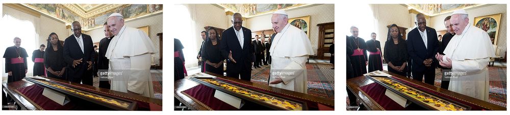 Pope Francis meets with dignitaries in a formal Vatican audience room, exchanging gifts at an ornate wooden table.