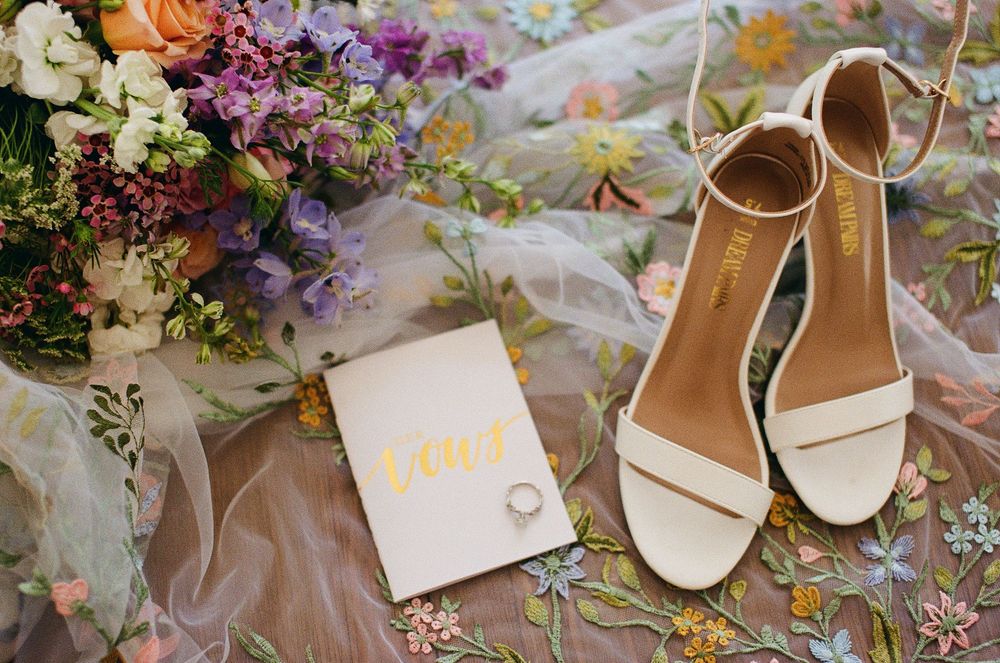 A film photo showing wedding details such as shoes, vows, and wedding rings.