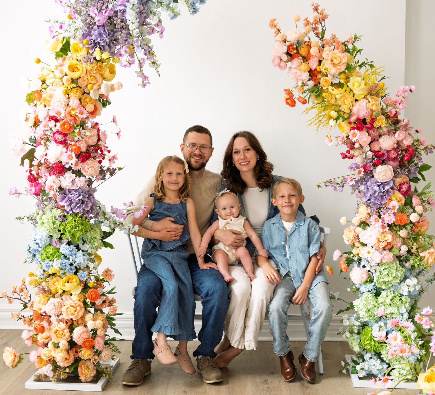 A family under a flower arch.