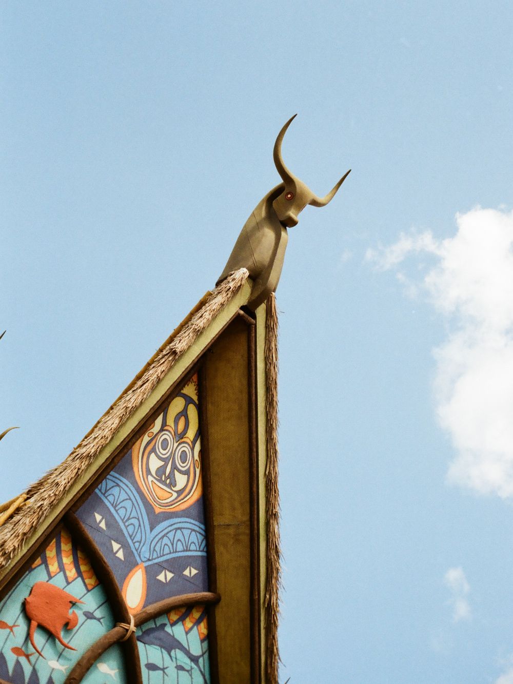 Decorative bull horns sculpture atop colorful tribal-themed building rooftop at Disney World Animal Kingdom.