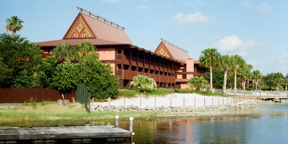 Disney's Polynesian Village Resort on Seven Seas Lagoon, featuring tropical architecture and lush palm trees.