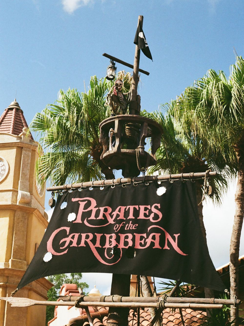 Pirates of the Caribbean attraction entrance sign with skeleton figure at Walt Disney World Magic Kingdom.