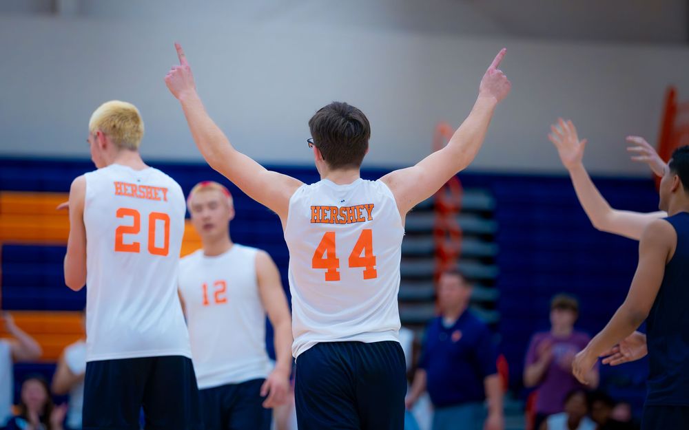 Hershey Trojan #44 raises both arms in celebration as teammates look on by Deanna Fox, SportsFox Photography based in Hershey PA.