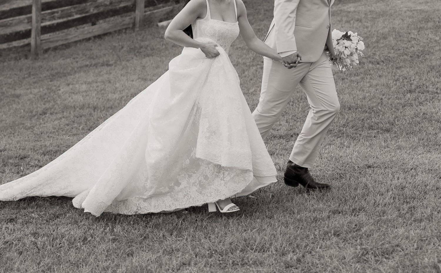 Black and white photo of a bride and groom sharing a romantic kiss at their wedding ceremony.