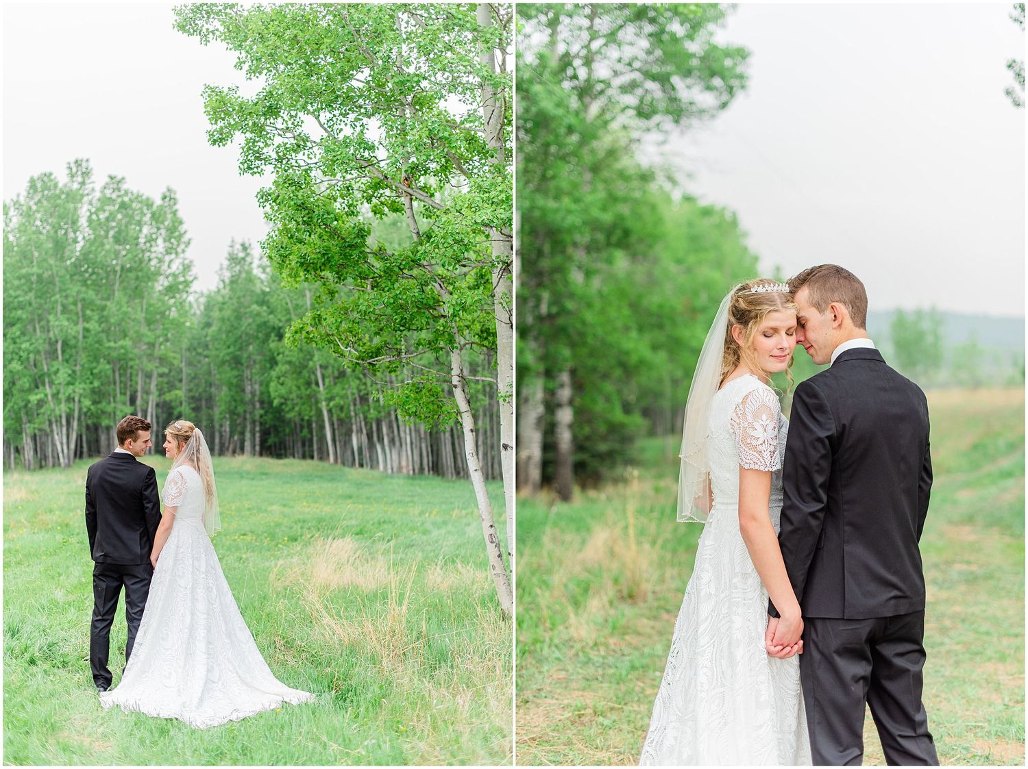 Bride in lace gown and groom in black suit pose together near birch trees in a green countryside setting.