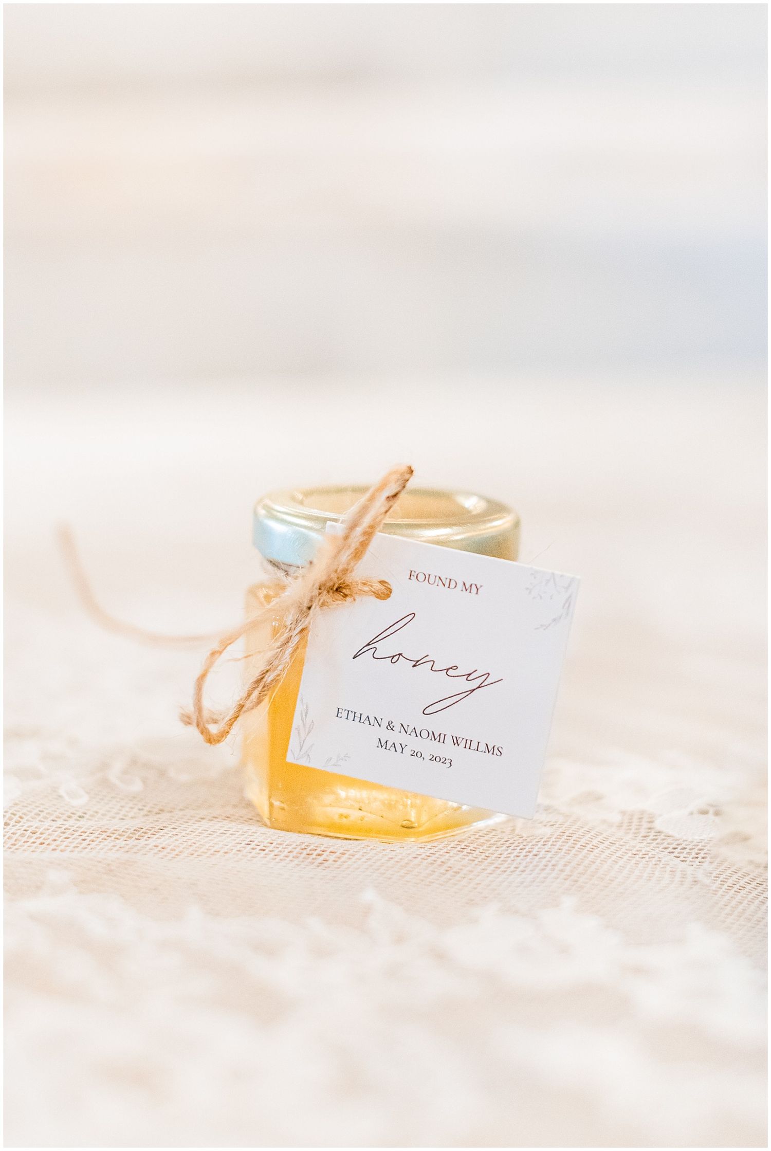 Small honey jar wedding favor with twine bow and tag reading Found My Honey for Ethan and Naomi Wilems.