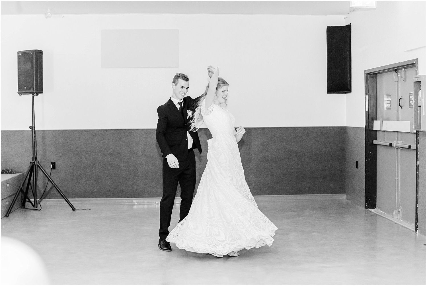 Bride and groom sharing their first dance in a black and white wedding reception photo.
