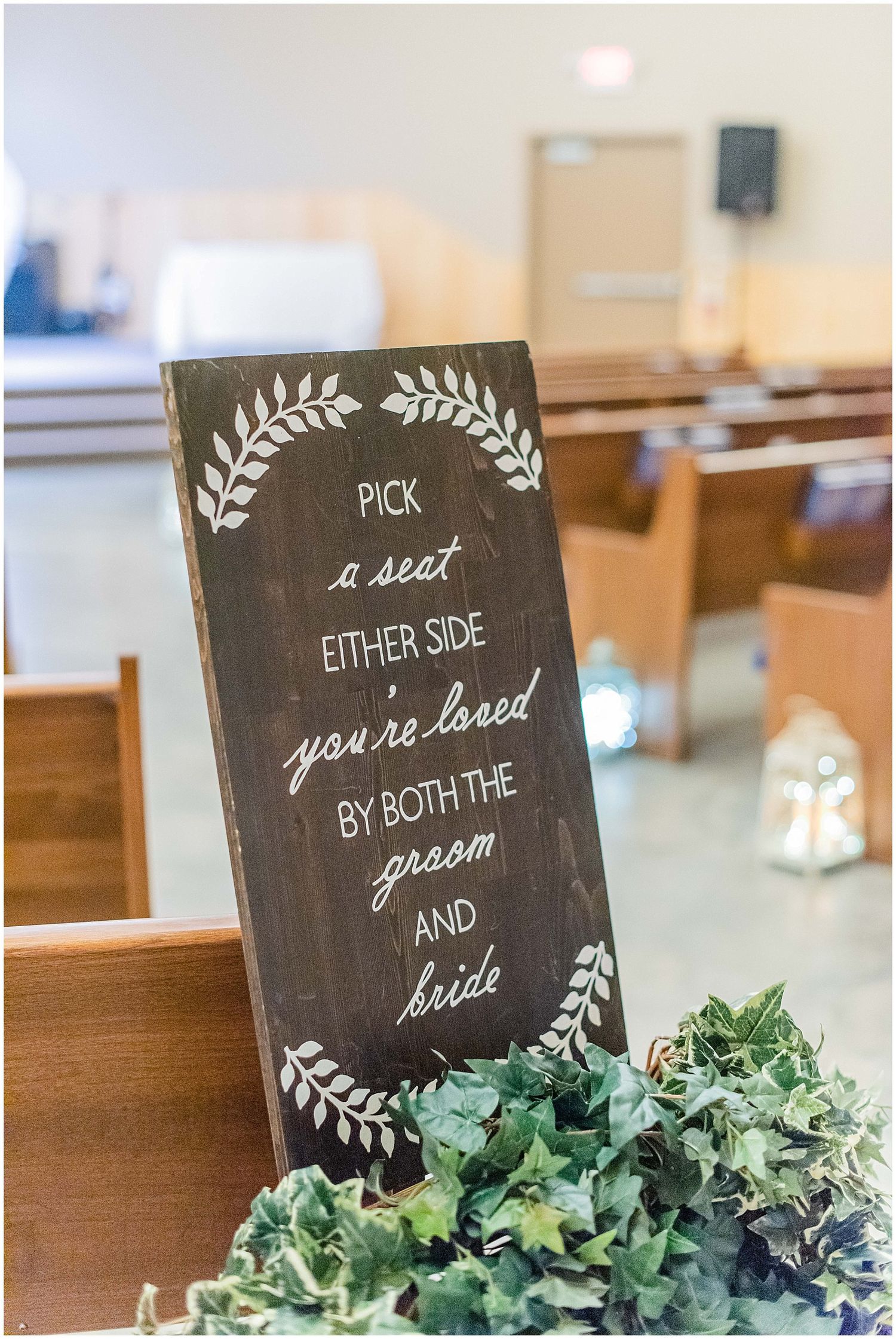 Rustic chalkboard wedding sign reading pick a seat either side youre loved by both the groom and bride with ivy decor.