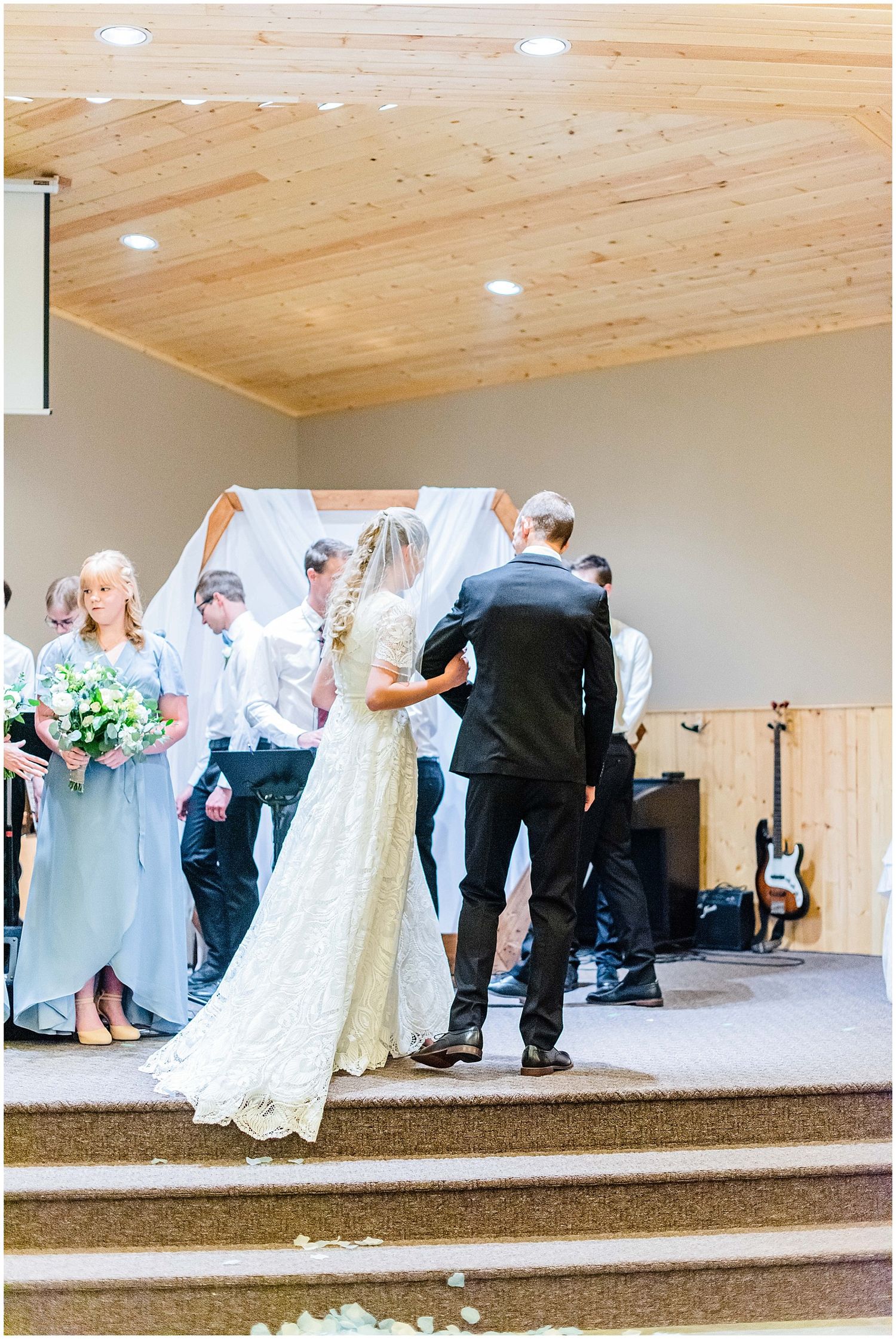 Bride and groom share a moment at the altar during a church wedding ceremony with bridesmaids.