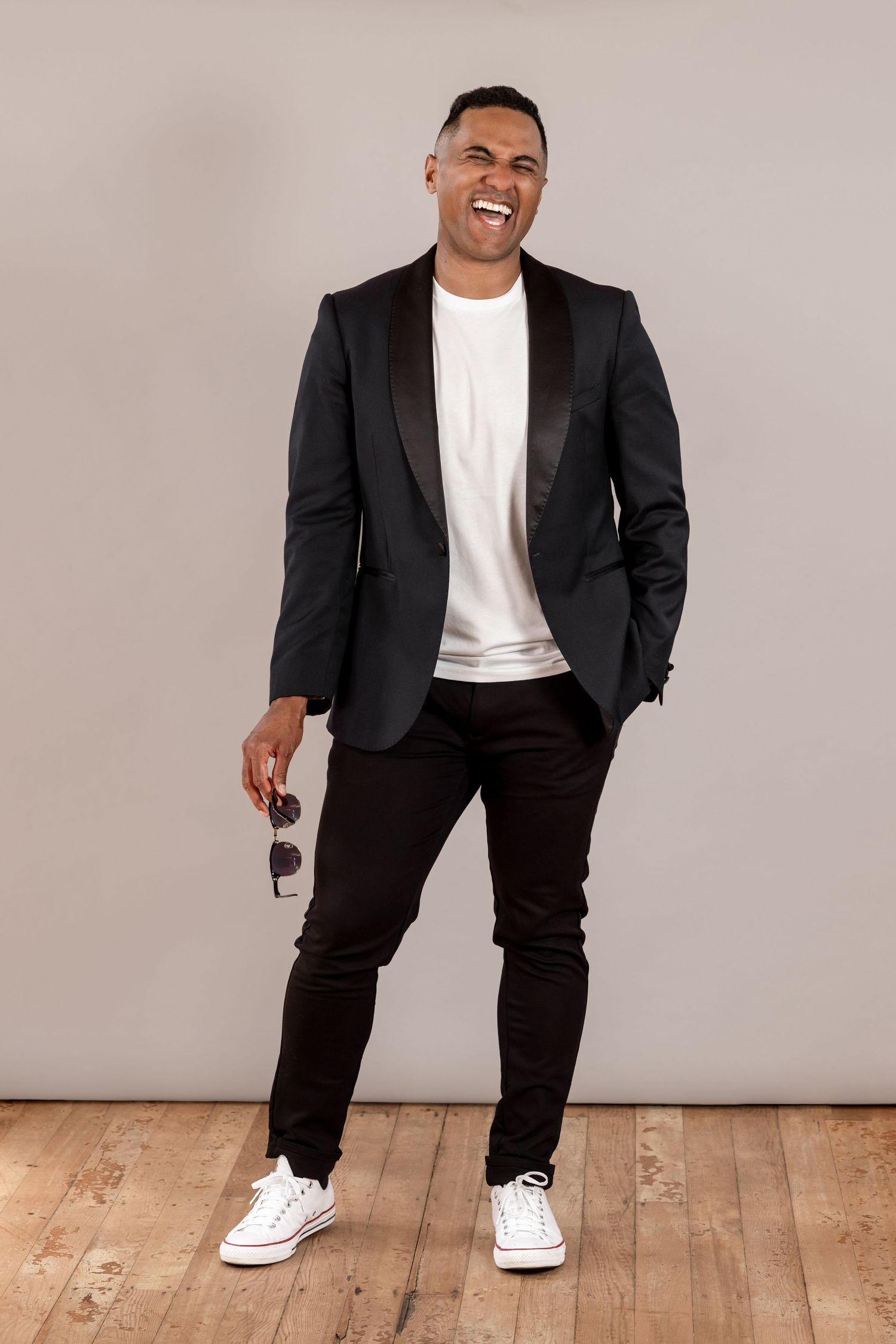 A fun professional Portrait of Maori man in smart casual clothes. Holding sun glasses in hand, having a laugh. Personal branding portrait