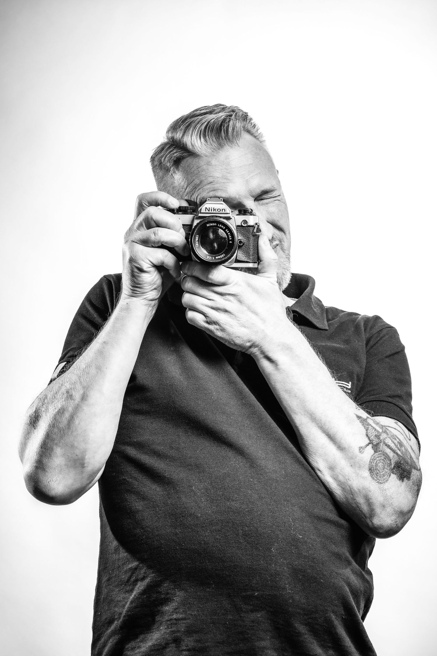 Zelfportret van fotograaf Bart Boodts met Nikon camera, zwart wit portret tijdens fotograferen, personal branding voor LinkedIn profielfoto.