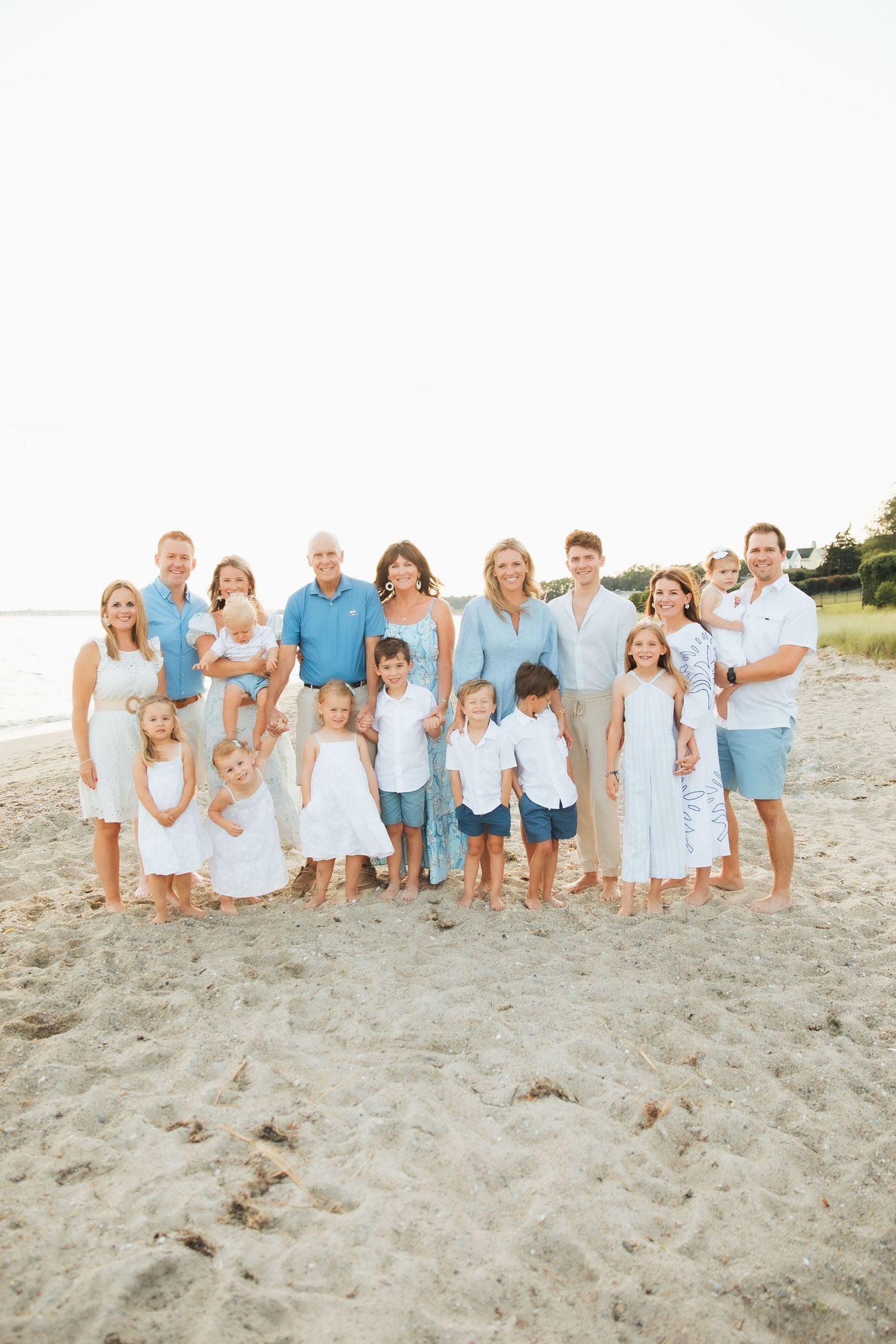 Large family group portrait on sandy beach.  extended family photoshoot