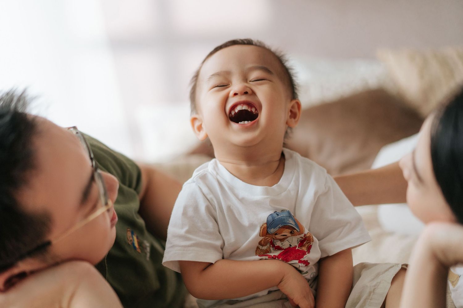 A series of candid photos showing joyful laughter and tender family moments in warm, natural lighting.一系列抓拍照片，展現了在溫暖自然的光線下，家人歡聲笑語的溫馨瞬間。