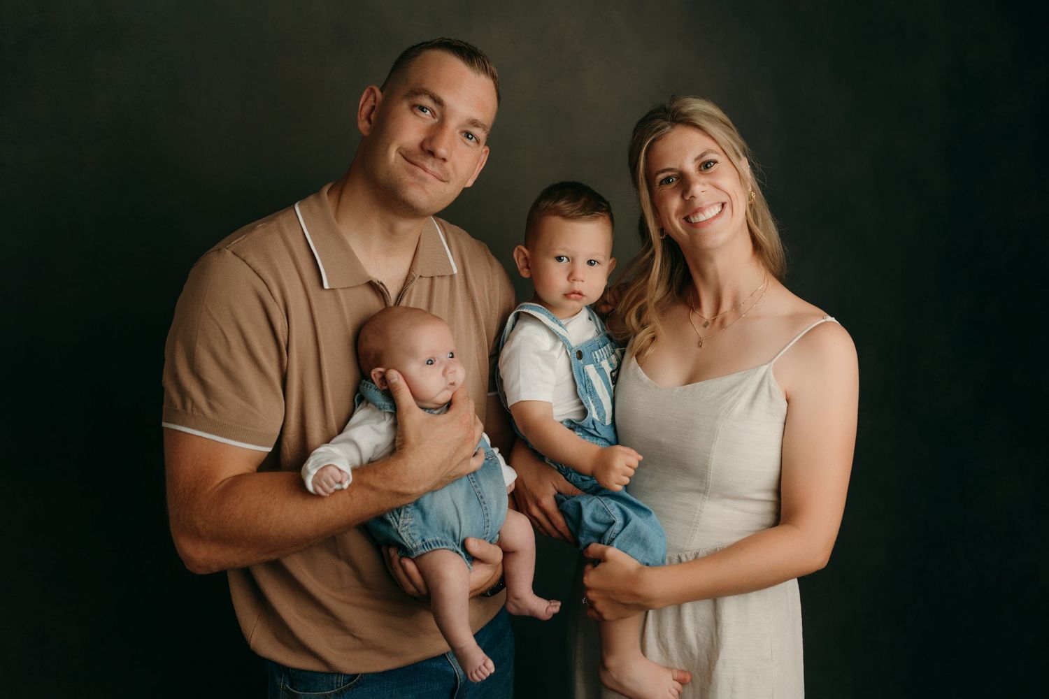 A family wearing neutral tones poses together at the family photo studio in Victoria BC