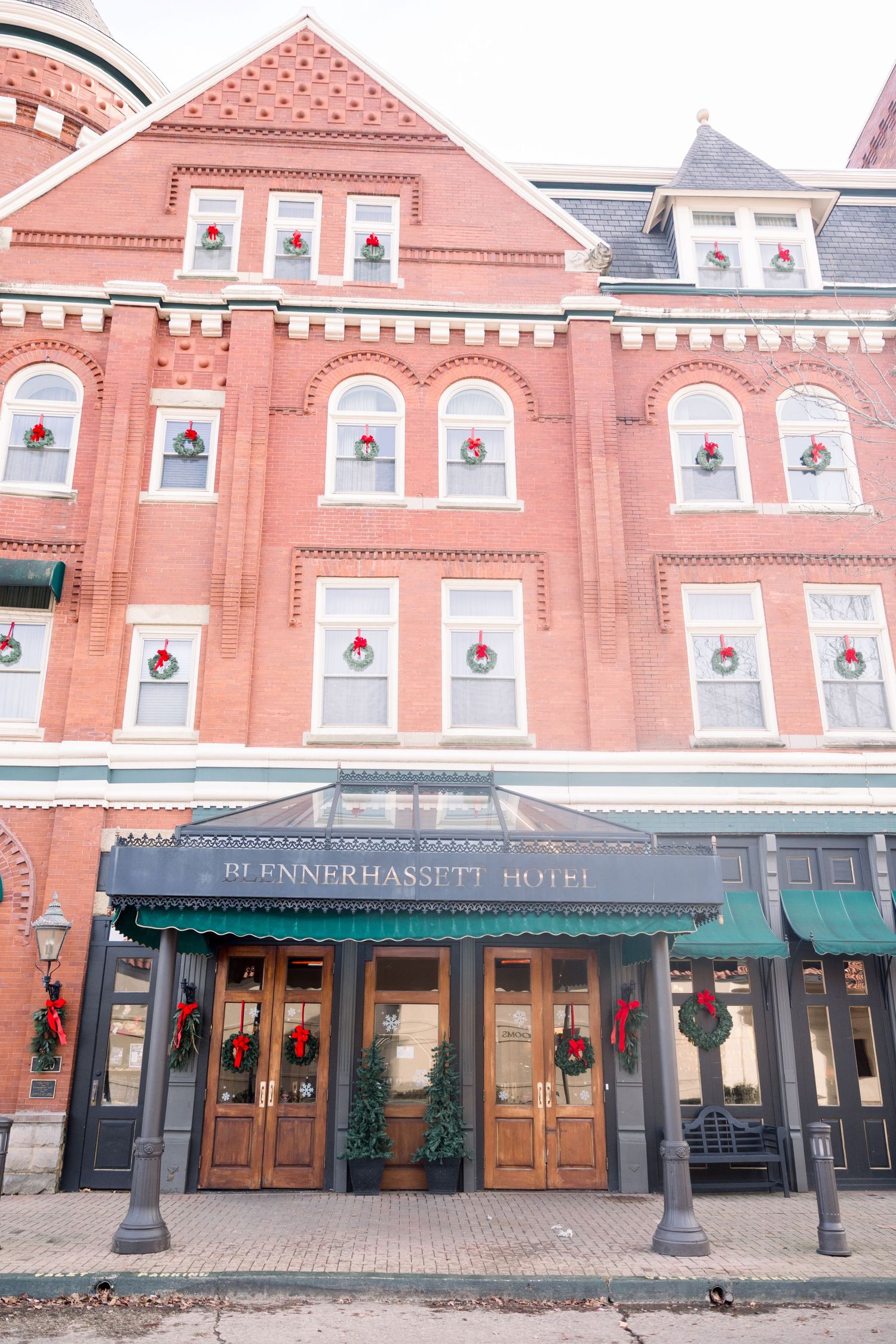 Historic red brick market building with ornate Victorian architecture and covered walkway entrance in downtown location.